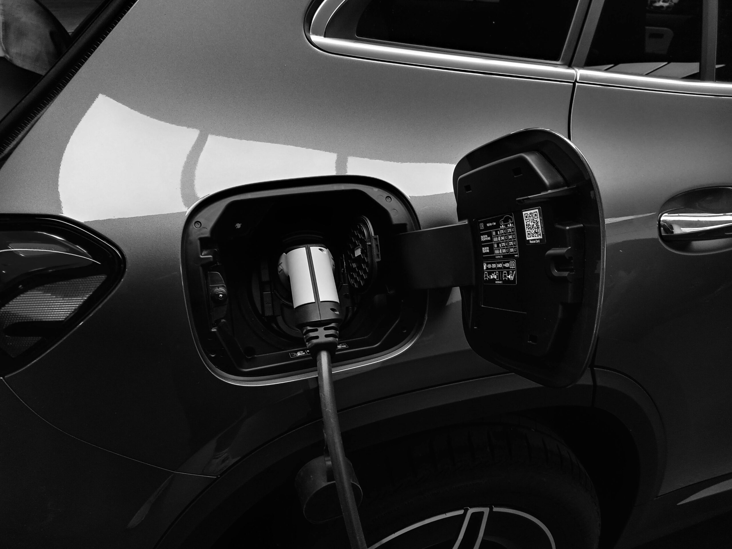 Dark EV Charging A dark EV plugged in via the charging port.