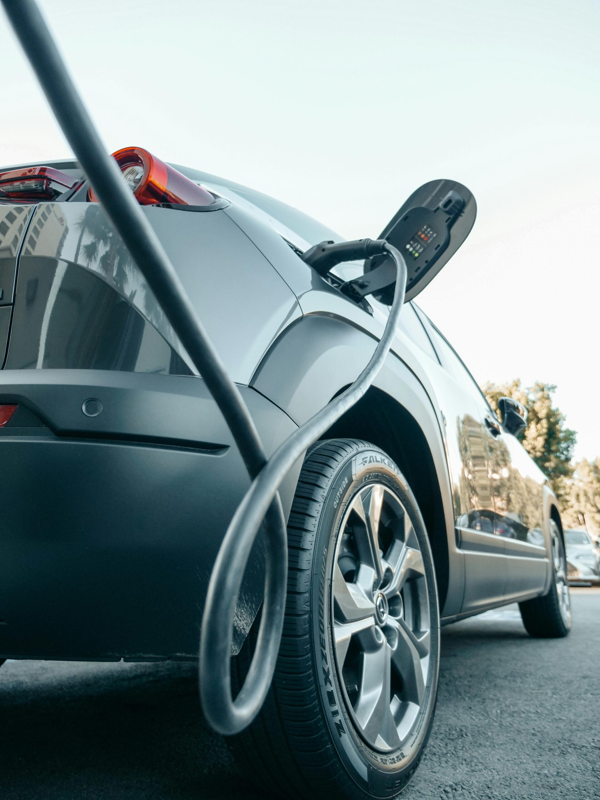 Low Angle EV Charger A low angle view of an EV plugged in to a charger.