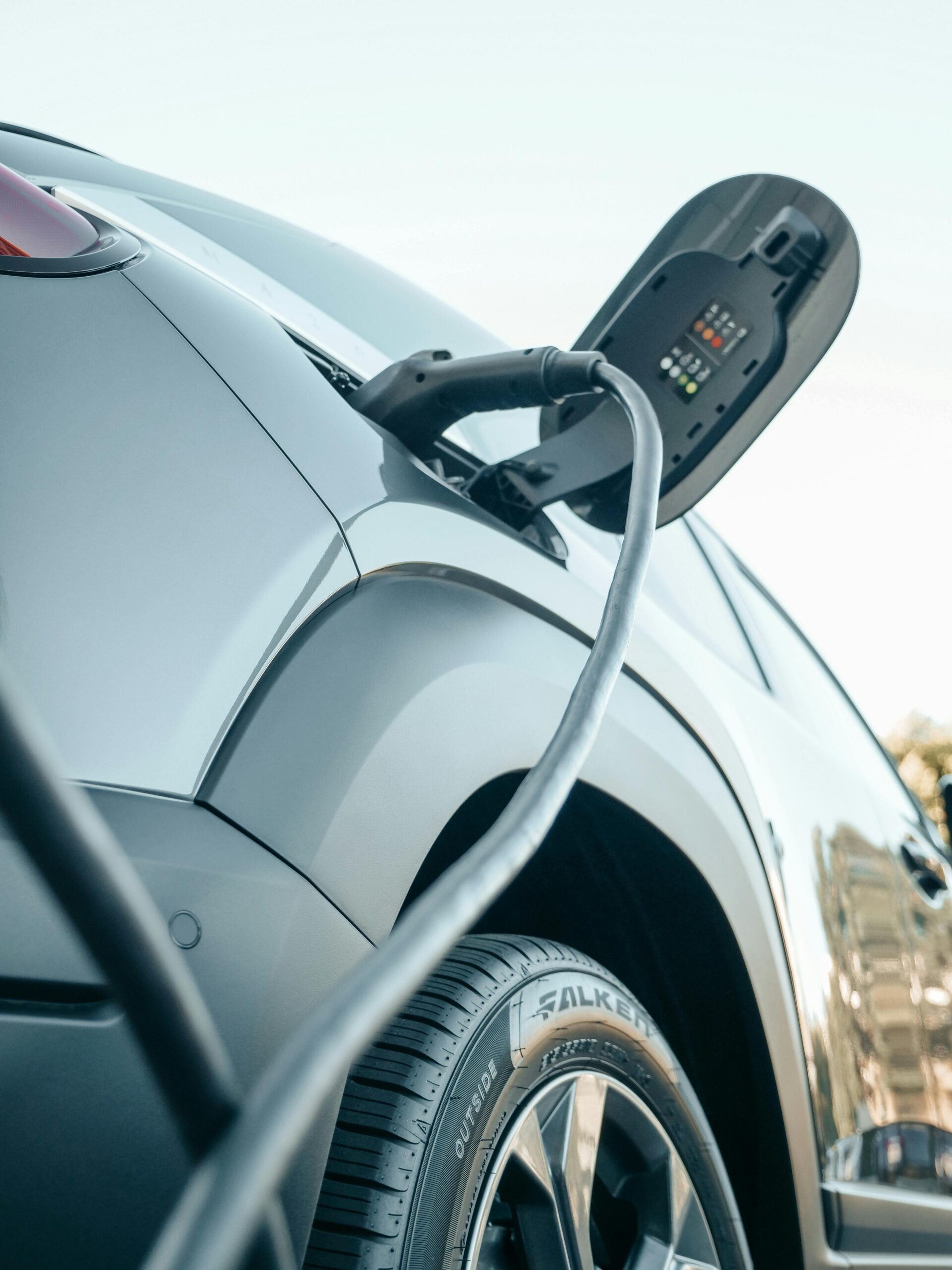 Low Angle Close Up EV Charging A low-angle close-up of an EV plugged in to a charger.