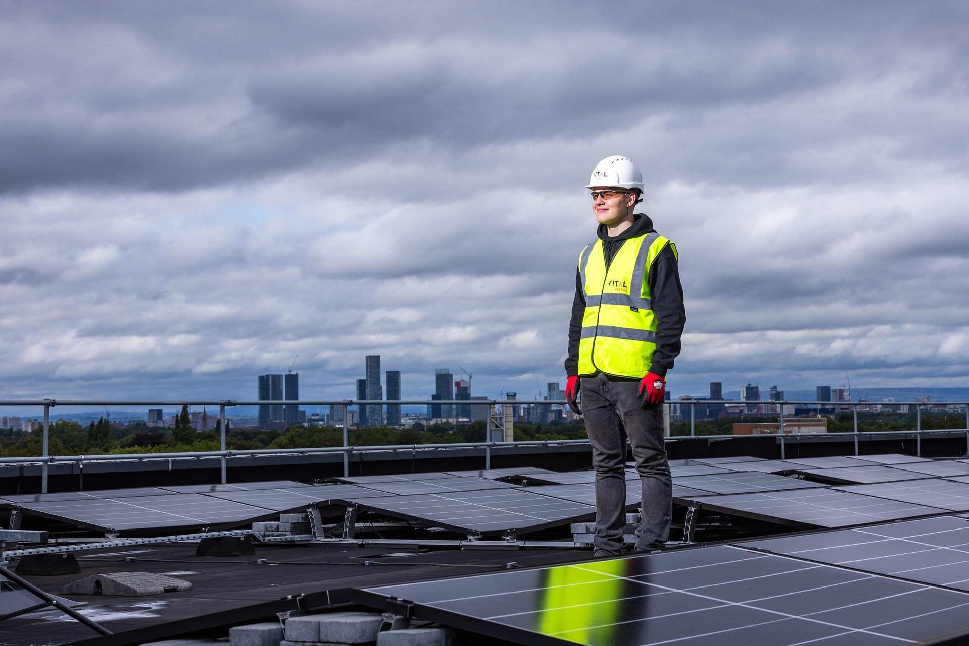 Man On A Roof in a high vis, surrounded by solar panels.