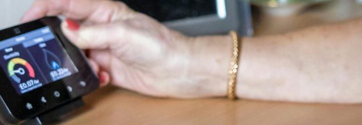An old person holding their smart meter in the cost of living crisis.