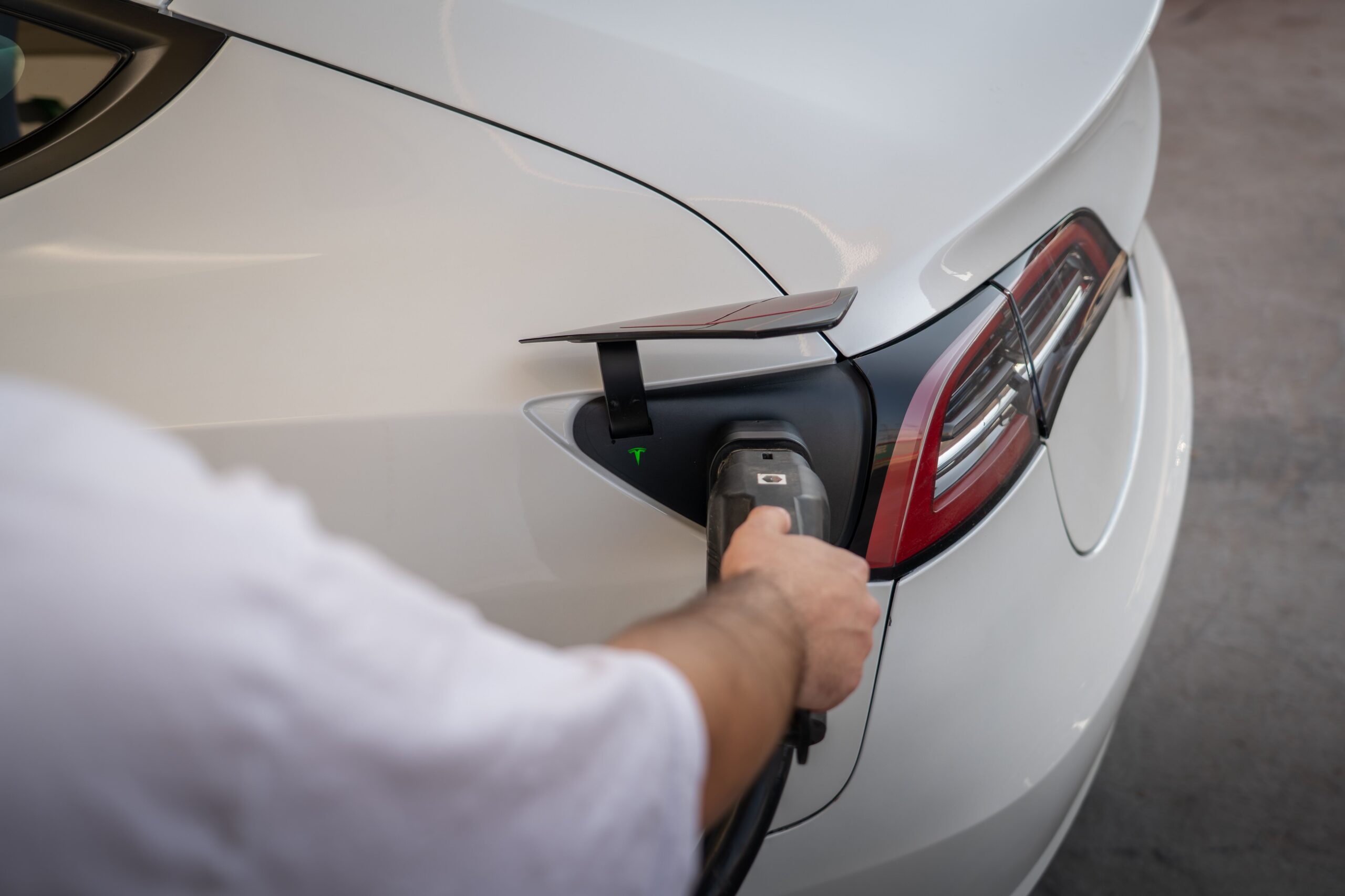 Close-up of a Tesla being charged, emphasizing modern sustainable technology