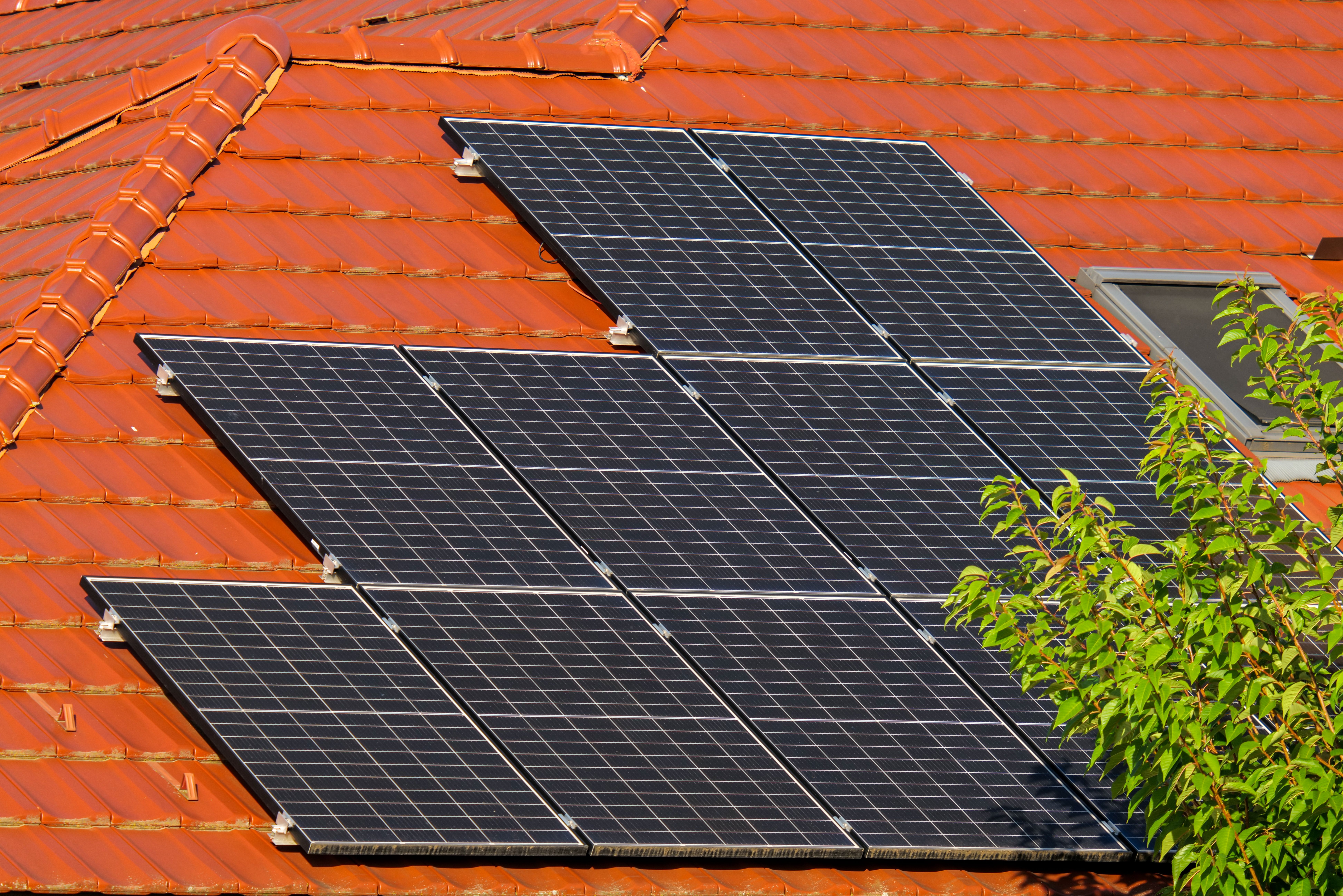 Close-up of solar panels on a red tiled roof.