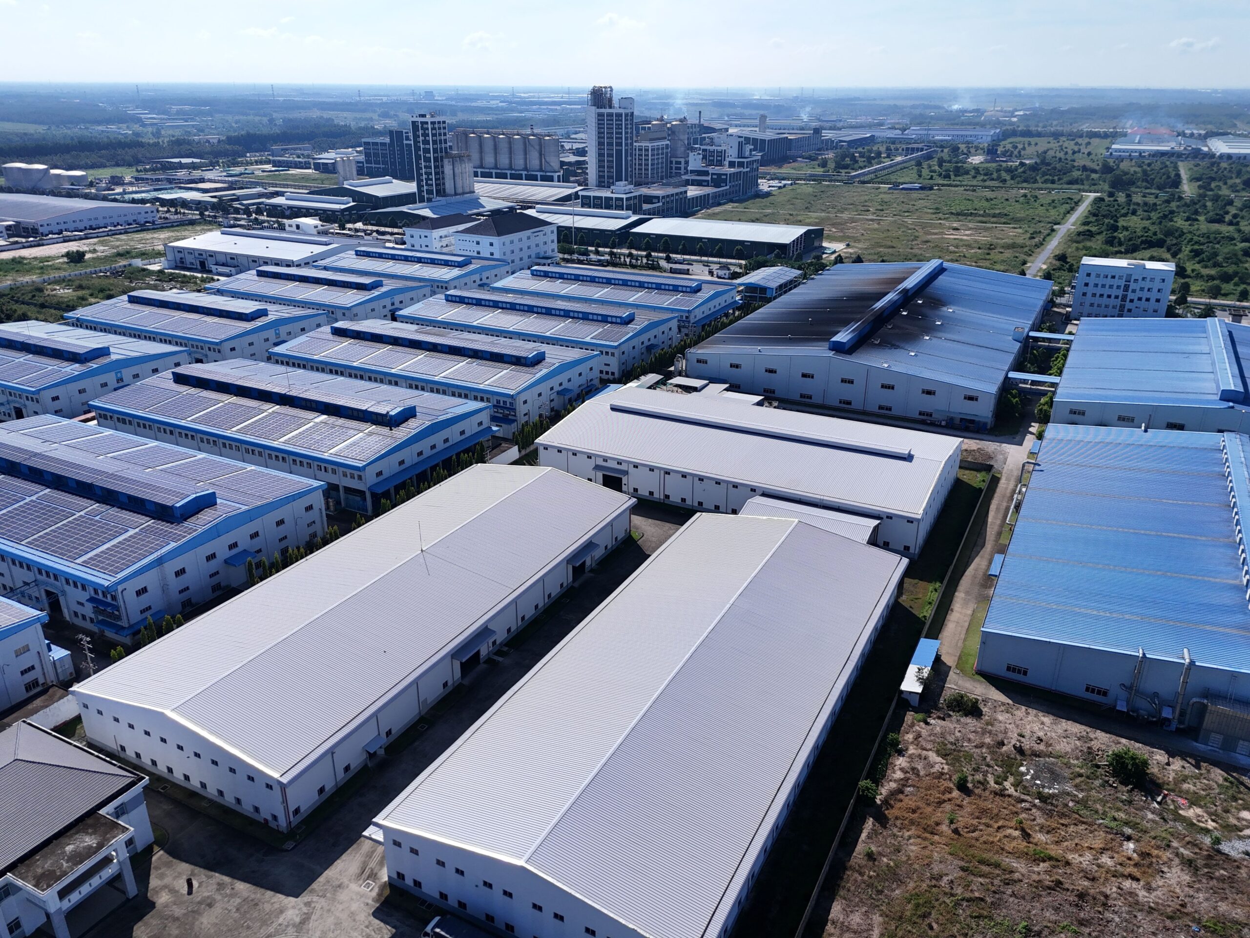 Aerial shot showcasing a large industrial park with solar panels on warehouse roofs.